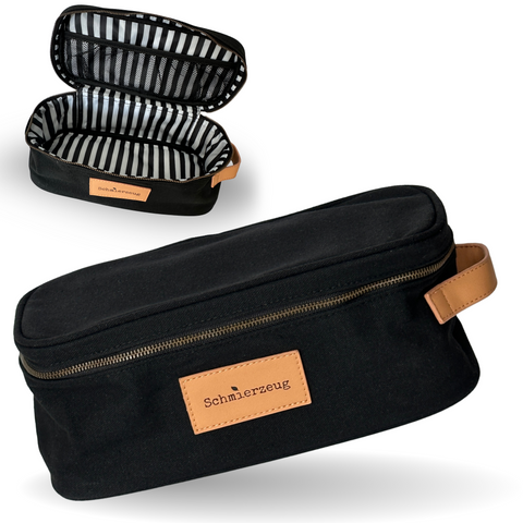 gezeigt wird der schwarze recycling Kulturbeutel von außen und innen. Innen ist er schwarzweiß gestreift und hat ein Netzfach sowie ein kleines Seitenfach. 